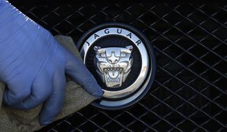 FILE - In this file photo taken on Wednesday, Sept. 28, 2016, a worker polishes a Jaguar logo on a car at a Jaguar dealer in London. Jaguar Land Rover is opening a new US$1.6 billion plant for the luxury car maker in Slovakia, its first on the continental Europe. The U.K.-based company, which is owned by India&#x27;s Tata Motors, has built the plant near the city of Nitra, about 100 kilometers (65 miles) west of the capital, Bratislava, that should initially produce 150,000 cars a year which could later increase to up to 300,000. (AP Photo/Frank Austin, file)