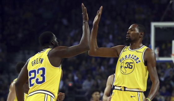Golden State Warriors&#x27; Kevin Durant, right, celebrates a score against the Washington Wizards with Draymond Green (23) during the first half of an NBA basketball game, Wednesday, Oct. 24, 2018, in Oakland, Calif. (AP Photo/Ben Margot) **FILE**