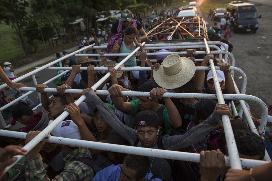 Migrants travel on a cattle truck, as a thousands-strong caravan of Central American migrants slowly makes its way toward the U.S. border, between Pijijiapan and Arriaga, Mexico, Friday, Oct. 26, 2018. Many migrants said they felt safer traveling and sleeping with several thousand strangers in unknown towns than hiring a smuggler or trying to make the trip alone. (AP Photo/Rodrigo Abd)
