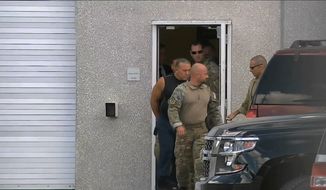 This frame grab from video provided by WPLG-TV shows FBI agents escorting Cesar Sayoc, in sleeveless shirt, in Miramar, Fla., on Friday, Oct. 26, 2018. Sayoc is an amateur body builder and former male stripper, a loner with a long arrest record who showed little interest in politics until Donald Trump came along. On Friday, he was identified by authorities as the Florida man who put pipe bombs in small manila envelopes, affixed six stamps and sent them to some of Donald Trump&#39;s most prominent critics. (WPLG-TV via AP)