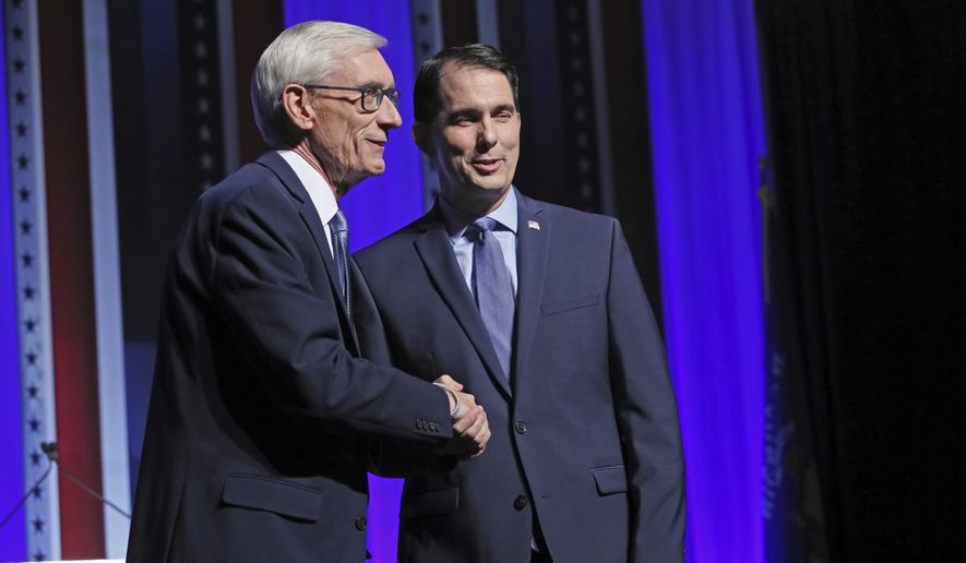 Republican Wisconsin Gov. Scott Walker, right, and Democratic challenger Tony Evers, left, meet onstage prior to the debate at the Zelazo Center on the University of Wisconsin-Milwaukee campus Friday, Oct. 26, 2018, in Milwaukee, Wis. (Michael Sears/Milwaukee Journal-Sentinel via AP)