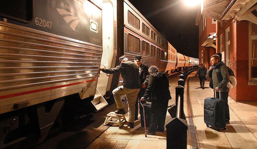 FILE - In this Dec. 16, 2016 photo, passengers board an Amtrak train at the Hinton Station in Hinton, W.Va. Hinton's Railroad Days festival every October brings in thousands of visitors who travel in by antique rail car from Huntington. (Rick Barbero /The Register-Herald via AP, File)