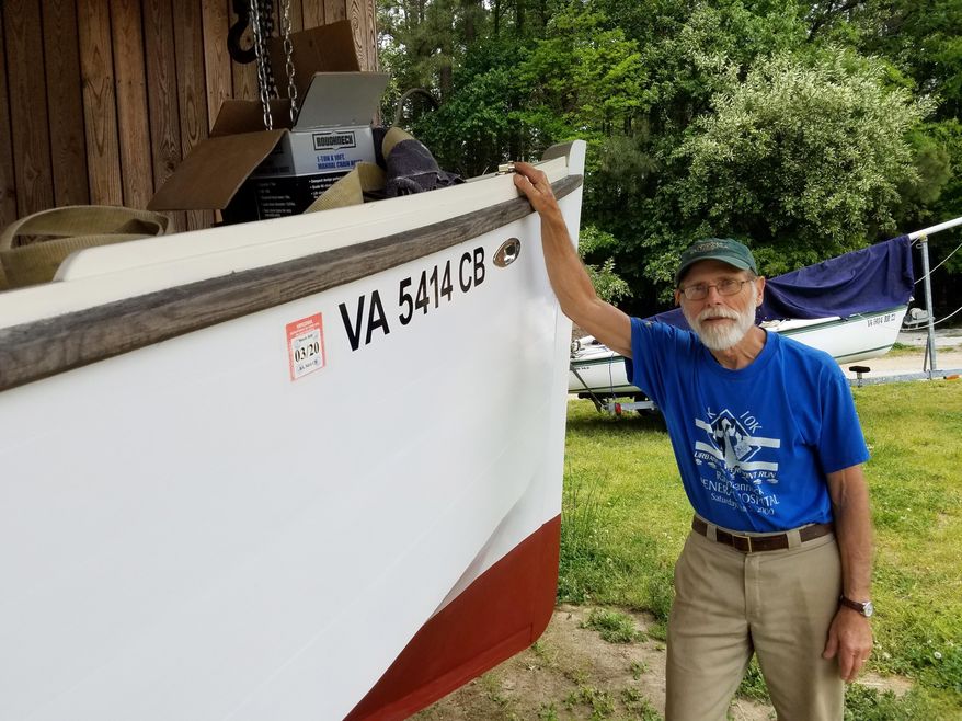 In this August 2018 photo, John England, who heads up the boat-building shop at the Deltaville Maritime Museum, stands by one of the many deadrise skiffs he has built at the facility in Deltaville, Va. One of the best things about the Deltaville Maritime Museum on the Middle Peninsula is the way it quite literally keeps the region's boat-building history alive. (Rob Hedelt/The Free Lance-Star via AP)