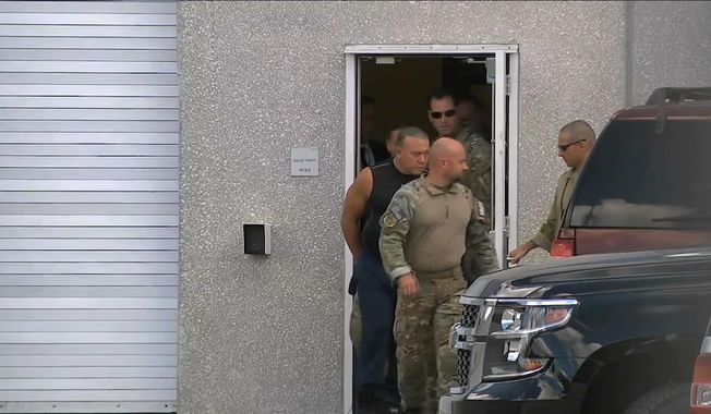 This frame grab from video provided by WPLG-TV shows FBI agents escorting Cesar Sayoc, in sleeveless shirt, in Miramar, Fla., on Friday, Oct. 26, 2018. Sayoc is an amateur body builder and former male stripper, a loner with a long arrest record who showed little interest in politics until Donald Trump came along. On Friday, he was identified by authorities as the Florida man who put pipe bombs in small manila envelopes, affixed six stamps and sent them to some of Donald Trump's most prominent critics. (WPLG-TV via AP)