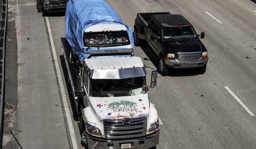 The van that federal agents are investigating in connection with package bombs that were sent to high-profile critics of President Donald Trump is transported on a  flatbed tow truck on Friday, Oct. 26, 2018 in Miramar, Fla.  Federal authorities took Cesar Sayoc into custody Friday in connection with the mail-bomb scare that earlier widened to 12 suspicious packages sent to prominent Democrats from coast to coast.  (Carline Jean/South Florida Sun-Sentinel via AP)