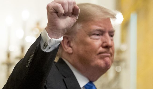 President Donald Trump holds up a fist after speaking at the 2018 Young Black Leadership Summit in the East Room of the White House, Friday, Oct. 26, 2018, in Washington. (AP Photo/Andrew Harnik)