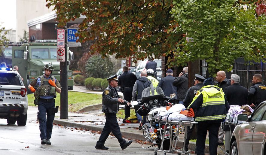 First responders surround the Tree of Life synagogue, rear center, in Pittsburgh, where a shooter opened fire Saturday, Oct. 27, 2018, wounding three police officers and causing "multiple casualties" according to Police. (AP Photo/Gene J. Puskar)
