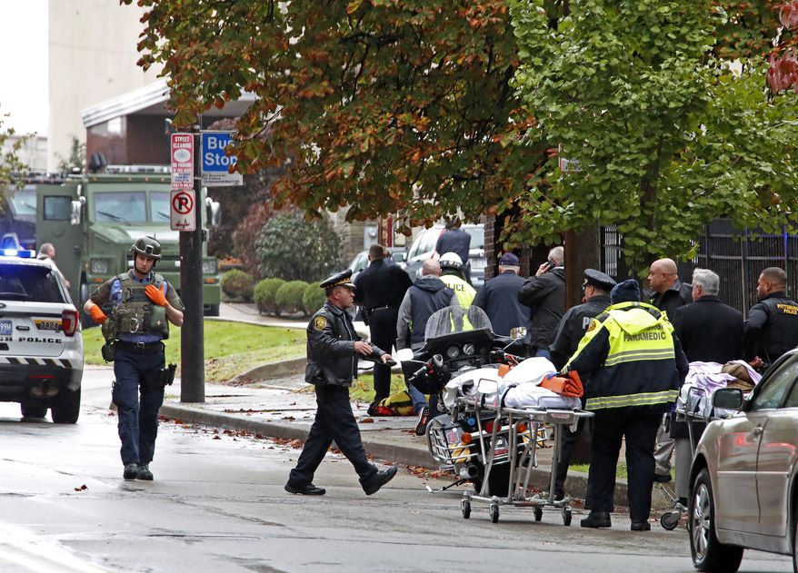 First responders surround the Tree of Life synagogue, rear center, in Pittsburgh, where a shooter opened fire Saturday, Oct. 27, 2018, wounding three police officers and causing "multiple casualties" according to Police. (AP Photo/Gene J. Puskar)
