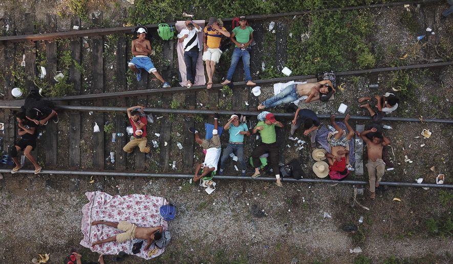 Migrants, who are part of a caravan of Central American migrants slowly makes its way toward the U.S. border, rest on the rails in Arriaga, Mexico, Friday, Oct. 26, 2018. Many migrants said they felt safer traveling and sleeping with several thousand strangers in unknown towns than hiring a smuggler or trying to make the trip alone. (AP Photo/Rodrigo Abd)