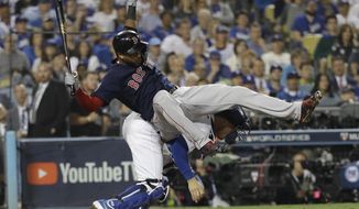 Boston Red Sox&#39;s Eduardo Nunez is upended by Los Angeles Dodgers catcher Austin Barnes while Barnes tried to field a wild pitch during the 13th inning in Game 3 of the World Series baseball game on Friday, Oct. 26, 2018, in Los Angeles. (AP Photo/David J. Phillip)