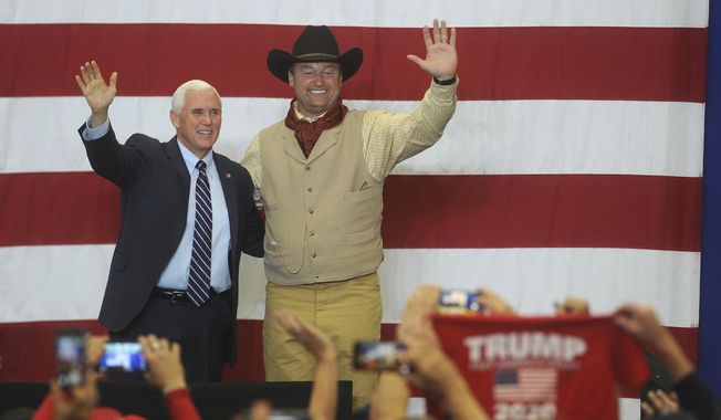 Vice President Mike Pence, left, and U.S. Senator Dean Heller wave to their supporters at the Carson City Airport on Saturday, Oct. 27, 2018, in Carson City, Nev. (JasonBean/The Reno Gazette-Journal via AP)