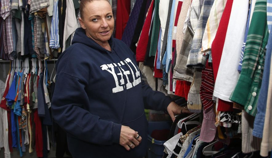 Angel Nelson is pictured in the apparel closet at the Oklahoma City Day Shelter in Oklahoma City, Wednesday, Sept. 26, 2018. Nelson had three children when she did her first 18-month stint in an Oklahoma prison at age 24 for writing a bogus check. Nelson finished her most recent stint in March and now works two jobs. (AP Photo/Sue Ogrocki)