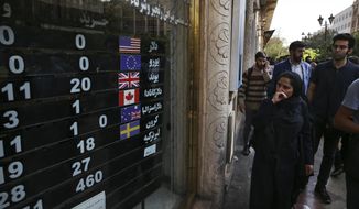 FILE - In this Oct. 2, 2018, file photo, an exchange shop displays rates for various currencies, in downtown Tehran, Iran. A battle is brewing between the Trump administration and some of the president’s biggest supporters in Congress who are concerned that sanctions to be re-imposed on Iran early next month won’t be tough enough. (AP Photo/Vahid Salemi, File)