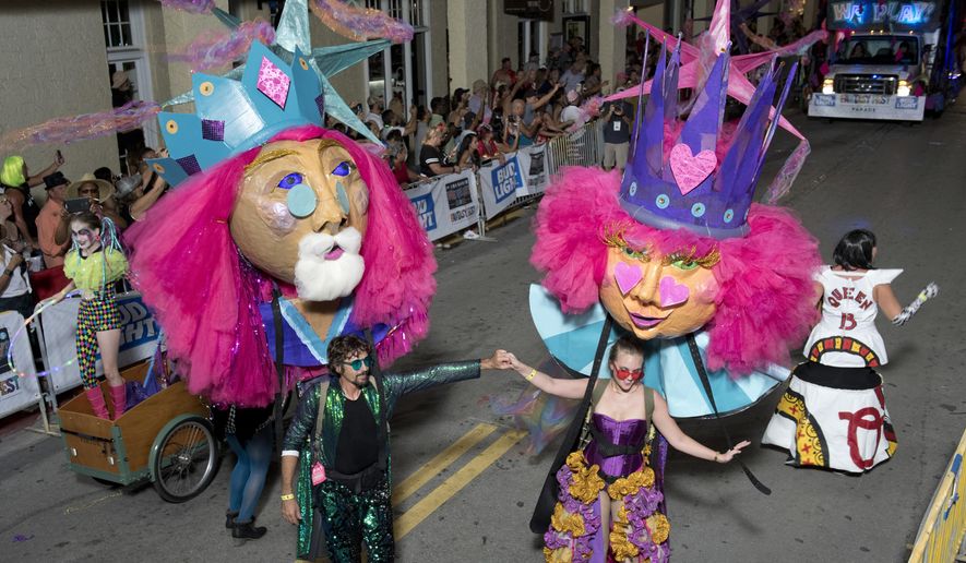 In this Saturday, Oct. 27, 2018, photo provided by the Florida Keys News Bureau, revelers supporting king and queen puppets make their way up Duval Street during the Fantasy Fest Parade in Key West, Fla. The extravaganza was the highlight event of the 10-day Fantasy Fest costuming and masking festival that ends Sunday, Oct. 28. (Rob O&#x27;Neal/Florida Key News Bureau via AP)