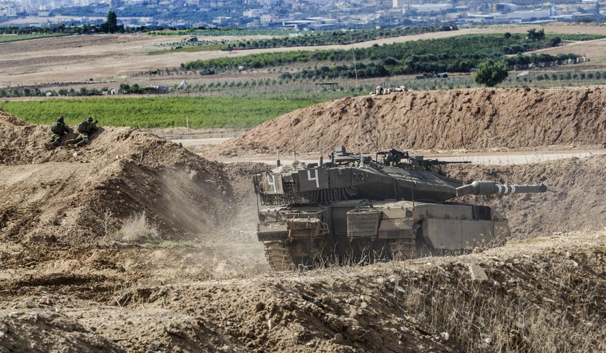 Israeli tank takes a position at the Gaza Strip border, Saturday, Oct. 27, 2018. The Israeli military has struck dozens of targets across the Gaza Strip in response to heavy rocket fire and threatened to expand its air campaign to Syria after accusing Iranian forces in Damascus of orchestrating the rocket attacks. (AP Photo/Tsafrir Abayov)