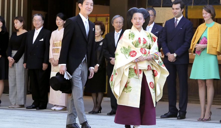 Japanese Princess Ayako, center right, the third daughter of the late Prince Takamado, dressed in traditional ceremonial gown, and Japanese businessman Kei Moriya, center left, arrive at Meiji Shrine for their wedding ceremony in Tokyo, Monday, Oct. 29, 2018.(Kyodo News via AP)