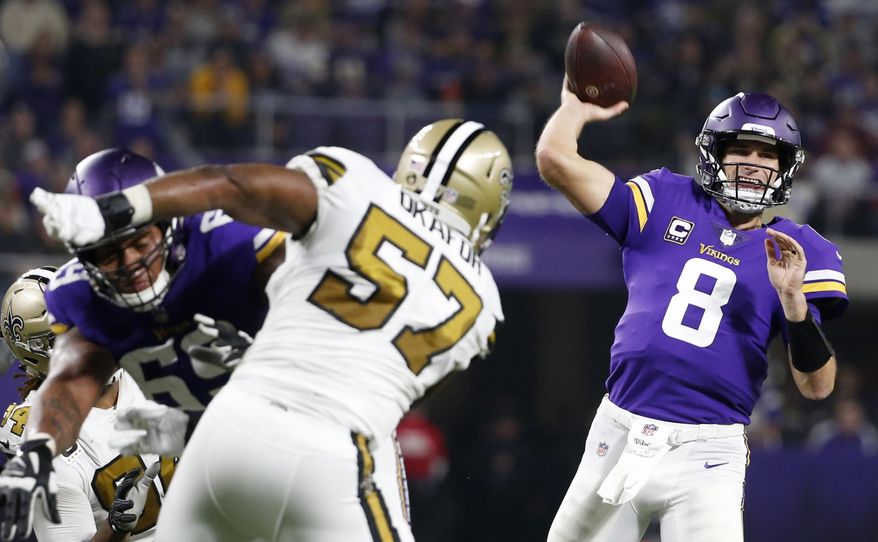 Minnesota Vikings quarterback Kirk Cousins (8) throws a pass over New Orleans Saints defensive end Alex Okafor (57) during the first half of an NFL football game, Sunday, Oct. 28, 2018, in Minneapolis. (AP Photo/Bruce Kluckhohn)