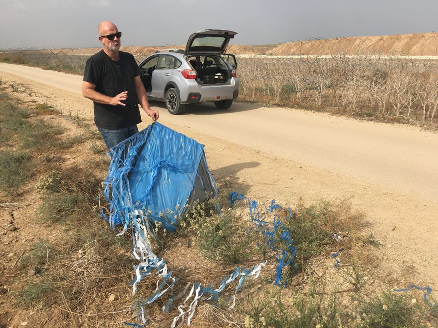 David Bing, a farmer from Kibbutz Kfar Aza, finds an incendiary kite on his farm fields, sent over from Gaza with the intention of starting fires in Israel. (photograph by Laura Kelly)