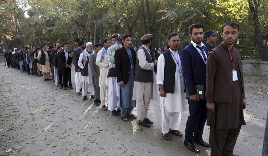 FILE - In this Saturday, Oct. 20, 2018 file photo, Afghan men line up to cast their votes, outside a polling station during the Parliamentary election in Kabul, Afghanistan. A new survey released last Friday, has found record lows in how Afghans rate their chances for a better life. Afghans worry more, laugh less and are the most pessimistic about their future than any other country surveyed by Gallup since 2006, when the organization first began to measure how good people feel about themselves, their lives and their prospects. (AP Photo/Rahmat Gul, File)