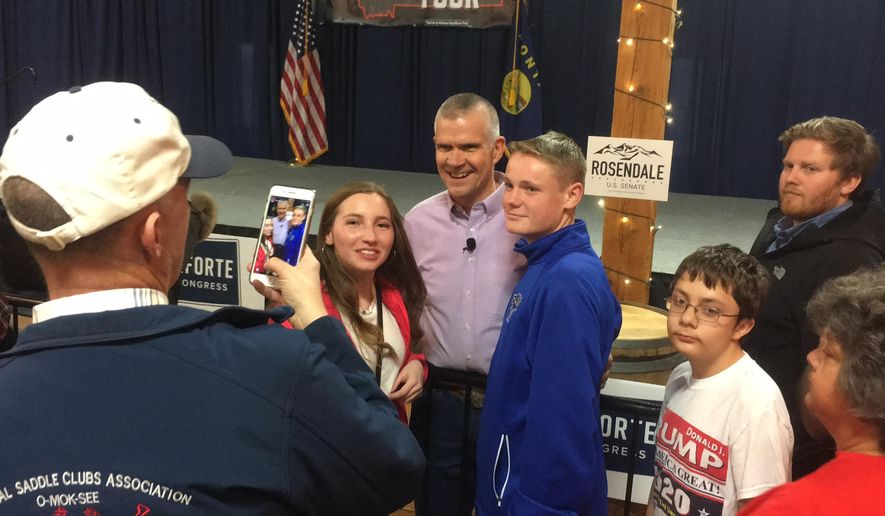 In this Friday, Oct. 26,2018 photo Republican Senate candidate Matt Rosendale poses for a photograph with supporters after a rally in East Helena, Mont. Rosendale is in a tight race against incumbent Democratic Sen. Jon Tester. (AP Photo/Matt Volz)