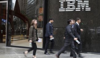 In this April 26, 2017, file photo, pedestrians walk past the IBM logo displayed on the IBM building in New York. Shares of Red Hat skyrocketed at the opening bell Monday, Oct. 29, 2018, after IBM, in the biggest acquisition in its 100-year history, acquired the software company. (AP Photo/Mary Altaffer, File) **FILE**