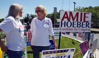 In this Thursday, June 14, 2018, file photo, Amie Hoeber, right, a Republican who is running in the Maryland 6th Congressional District primary, talks to a supporter at an early voting center in Frederick, Md. (AP Photo/Brian Witte)