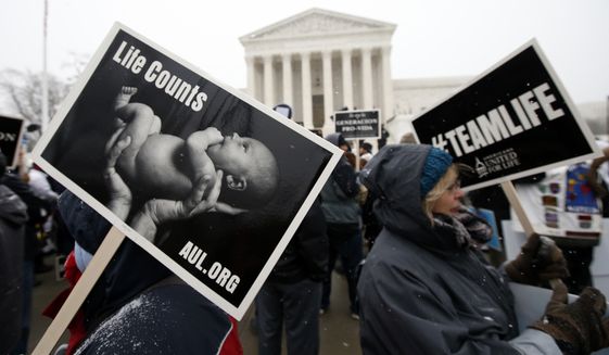 Signs are carried during the March for Life 2016, in front of the U.S. Supreme Court, Friday, Jan. 22, 2016, in Washington, during the annual rally on the anniversary of 1973 &quot;Roe v. Wade&quot; U.S. Supreme Court decision legalizing abortion. (AP Photo/Alex Brandon) ** FILE **