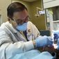 In this Oct. 18, 2018, photo, dentist Kou Vang works on a patient in his St. Paul, Minn. office. Vang, 63, didn&#39;t get around to dentistry until he was in his 40s. He was told he was the first Hmong to go into dentistry in Minnesota, and probably the first grandfather to graduate from his program. That&#39;s because Vang&#39;s life took him the long way, through war, prison camp, destitution, immigration and a lot of hard work. (Scott Takushi/Pioneer Press via AP)