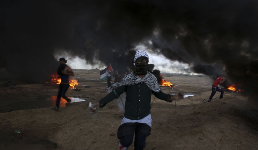 Protesters run when burn tires near the fence of the Gaza Strip border with Israel during a protest east of east of Gaza City, Friday, Oct. 26, 2018. (AP Photo/Adel Hana)