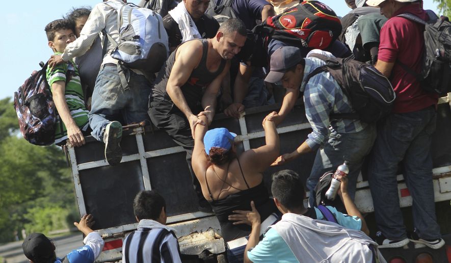 Migrants from El Salvador board a truck as they start on their way to the United States, from San Salvador, El Salvador, Wednesday, Oct. 31, 2018. A third group of migrants from El Salvador had already made it to Guatemala, and on Wednesday a fourth group of about 700 Salvadorans set out from the capital, San Salvador, with plans to walk to the U.S. border, 1,500 miles away. (AP Photo/Diana Ulloa)