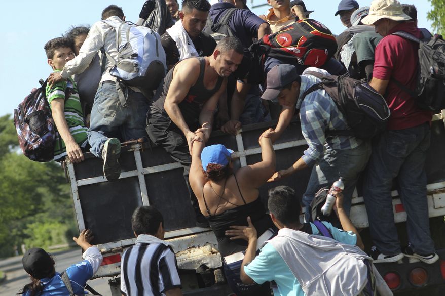 Migrants from El Salvador board a truck as they start on their way to the United States, from San Salvador, El Salvador, Wednesday, Oct. 31, 2018. A third group of migrants from El Salvador had already made it to Guatemala, and on Wednesday a fourth group of about 700 Salvadorans set out from the capital, San Salvador, with plans to walk to the U.S. border, 1,500 miles away. (AP Photo/Diana Ulloa)