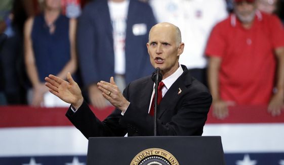 Florida Gov. Rick Scott gestures as he appears with President Donald Trump during a rally Wednesday, Oct. 31, 2018, in Estero, Fla. (AP Photo/Chris O&#39;Meara) ** FILE **