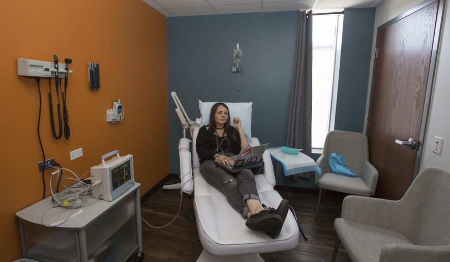 Lauren Pestikas sits as she receives an infusion of the drug ketamine during a 45-minute session at an outpatient clinic in Chicago on July 25, 2018. Pestikas struggled with depression and anxiety and made several suicide attempts before starting ketamine treatments earlier in the year. (AP Photo/Teresa Crawford)