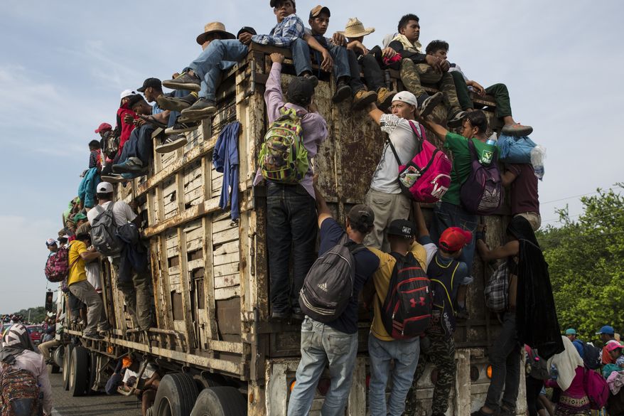 Members of a US-bound migrant caravan board a truck on their way north outside the town of Arriaga, Saturday, Oct. 27, 2018. Hundreds of Mexican federal officers carrying plastic shields had blocked the caravan from advancing toward the United States, after several thousand of the migrants turned down the chance to apply for refugee status and obtain a Mexican offer of benefits. (AP Photo/Rodrigo Abd)