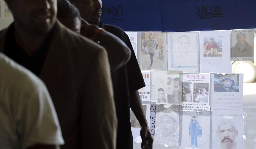 Men line up for a meal as posters for the missing line a window at a shelter for migrants in Tijuana, Mexico, on Oct. 19, 2018. As people worldwide flee war, hunger and a lack of jobs, global migration has soared to record highs, with more than 258 million international migrants in 2017. That is an increase of 49 percent from the turn of the century, according to the United Nations. (AP Photo/Gregory Bull)