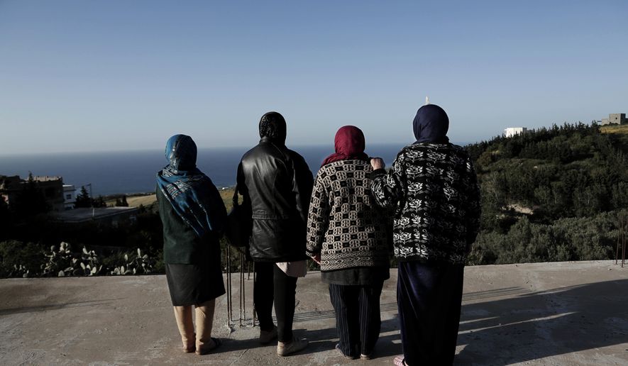 In this April 12, 2018 photo, women whose sons went missing look at the shoreline in the town of Ras Jabal, Bizerte, Tunisia. An Associated Press tally has documented at least 56,800 migrants dead or missing worldwide from 2014 to 2018 _ almost double the number found in the world’s only official attempt to count them, by the U.N.’s International Organization for Migration. (AP Photo/Nariman El-Mofty)