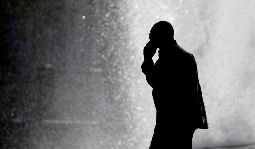 In this Thursday, Oct. 11, 2012, file photo, a pedestrian talking on a cellphone is silhouetted in front of a fountain in Philadelphia. Two U.S. government agencies are giving conflicting interpretations of a safety study on cellphone radiation: One says it causes cancer in rats. The other says there&#x27;s no reason for people to worry. (AP Photo/Matt Rourke) ** FILE **