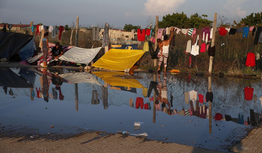 Water is left behind after migrants took showers with donated water brought in by truck, in an area where migrants are camping and doing laundry, as a thousands-strong caravan of Central Americans hoping to reach the U.S. border takes a rest day in Juchitan, Oaxaca state, Mexico, Wednesday, Oct. 31, 2018. Thousands of weary Central American migrants in a caravan rested Wednesday in southern Mexico while their representatives tried to negotiate transportation hundreds of miles ahead to the capital, but by evening there was bad news: they'd be walking again the next day. (AP Photo/Rebecca Blackwell)
