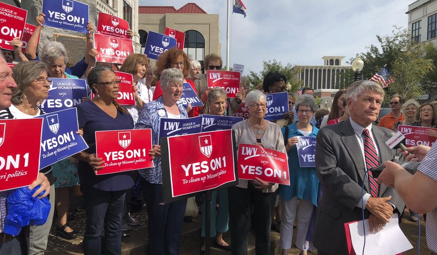 FILE - In this Aug. 31, 2018 file photo, supporters of Missouri's redistricting ballot measure hold signs behind former state Sen. Bob Johnson as he serves as their spokesman during a press conference outside the Cole County Courthouse in Jefferson City, Mo. Proposed state Constitutional Amendment 1 on the Nov. 6, 2018, ballot would require Missouri state House and Senate districts to be drawn to achieve "partisan fairness" and "competitiveness." (AP Photo/David A. Lieb, File)