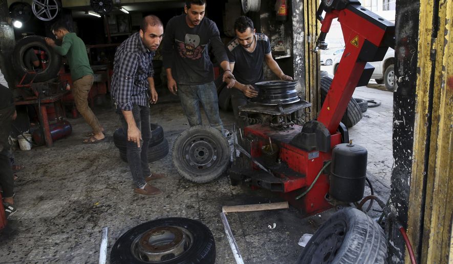 In this Tuesday, Oct. 30, 2018 photo, workers fix damaged tires at a workshop in Gaza City. Palestinians in the Gaza Strip have coped with shortages of just about everything in more than a decade of border closures -- from chocolate to medicines to fuel and building supplies. Now, the past six months of protests against an Israeli-Egyptian blockade have added an unexpected item to the list of those in short supply: car tires. (AP Photo/Adel Hana)