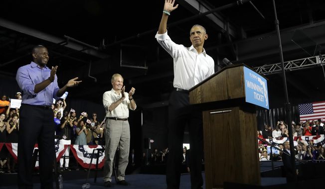 Former President Barack Obama, right, waves during a campaign rally with Democratic gubernatorial candidate Andrew Gillum, left, and U.S. Sen. Bill Nelson, D-Fla., center, Friday, Nov. 2, 2018, in Miami. (AP Photo/Lynne Sladky)