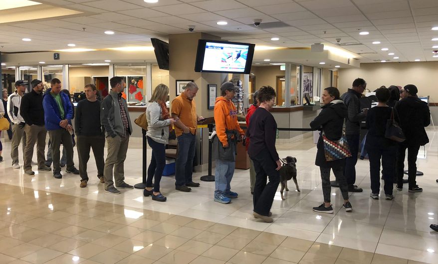 Voters wait in line at Boise City Hall in Boise, Idaho, to cast ballots in early voting Friday, Nov. 2, 2018. An unusually high number of Idahoans have voted early, and two high-profile ballot initiatives appear to be driving some of the turnout. (AP Photo/Keith Ridler)