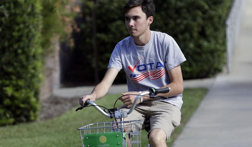 David Hogg, a student who survived the Stoneman Douglas High School shooting rides a bike on the campus of the University of Central Florida encouraging students to vote during a Vote for Our Lives event at the University of Central Florida in Orlando, Florida, Oct. 31, 2018. (AP Photo/John Raoux)  ** FILE **