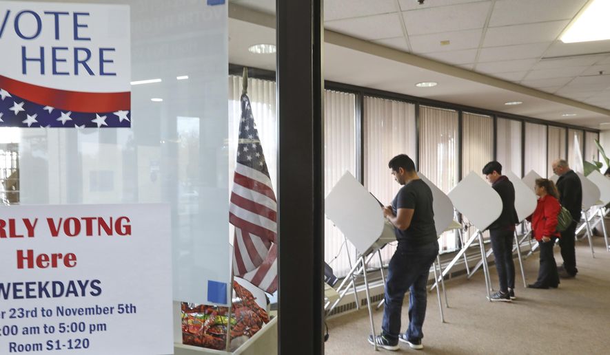 In this Wednesday, Oct. 31, 2018, photo, voters cast their votes in Salt Lake City. If a Utah race is too close to call on election night a distinct possibility in the slugfest between Republican Rep. Mia Love and Democrat Ben McAdams residents and candidates will have to wait patiently because the state's deliberate vote release schedule recommends counties wait three days before posting more results. (AP Photo/Rick Bowmer)