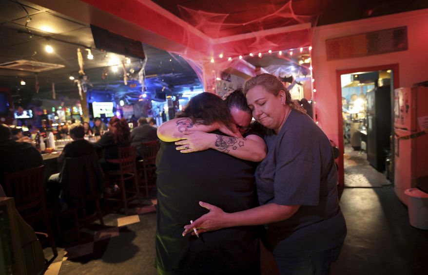 In this Wednesday, Oct. 31, 2018 photo, Bernie Gerlach, left, Jennifer Alomari, center, and Katie Topham, right, comfort each other as the Hershee Bar, Hampton Roads' last lesbian bar, is open for the final night in Norfolk, Va. (Steve Earley/The Virginian-Pilot via AP)