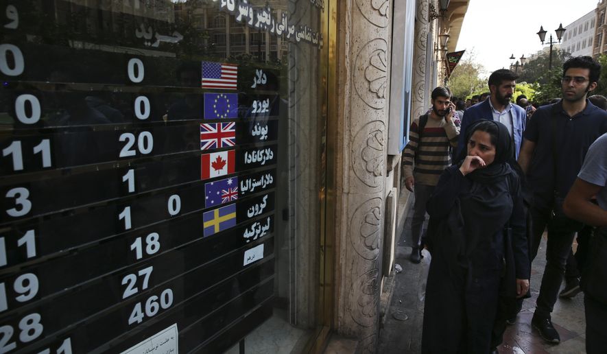 In this Oct. 2, 2018, file photo, an exchange shop displays rates for various currencies, in downtown Tehran, Iran. Iran is bracing for the restoration of U.S. sanctions on its vital oil industry set to take effect on Monday, Nov. 5, 2018, as it grapples with an economic crisis that has sparked sporadic protests over rising prices, corruption and unemployment. The oil sanctions will target the country’s largest source of revenue in the most punishing action taken since the Trump administration withdrew from the 2015 nuclear agreement in May. (AP Photo/Vahid Salemi, File)