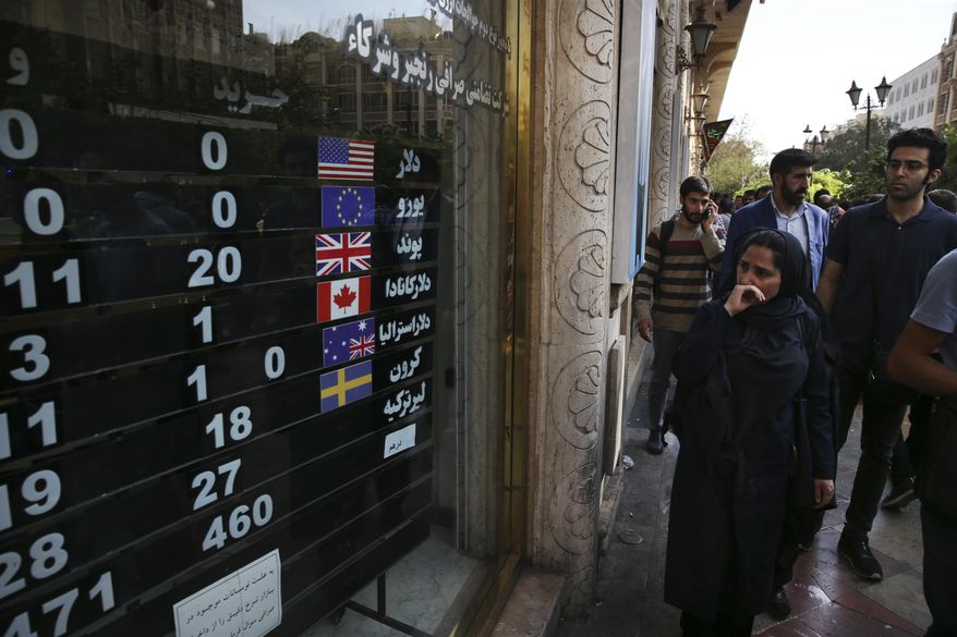 In this Oct. 2, 2018, file photo, an exchange shop displays rates for various currencies, in downtown Tehran, Iran. Iran is bracing for the restoration of U.S. sanctions on its vital oil industry set to take effect on Monday, Nov. 5, 2018, as it grapples with an economic crisis that has sparked sporadic protests over rising prices, corruption and unemployment. The oil sanctions will target the country’s largest source of revenue in the most punishing action taken since the Trump administration withdrew from the 2015 nuclear agreement in May. (AP Photo/Vahid Salemi, File)