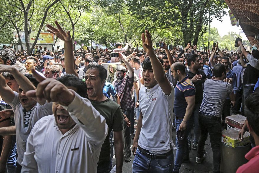 FILE - In this June 25, 2018 file photo, a group of protesters chant slogans at the old grand bazaar in Tehran, Iran. Iran is bracing for the restoration of U.S. sanctions on its vital oil industry set to take effect on Monday, Nov. 5, 2018, as it grapples with an economic crisis that has sparked sporadic protests over rising prices, corruption and unemployment. The oil sanctions will target the country’s largest source of revenue in the most punishing action taken since the Trump administration withdrew from the 2015 nuclear agreement in May. (Iranian Labor News Agency via AP, File)