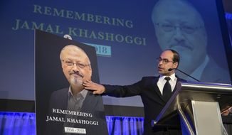 Nihad Awad, a close colleague of slain Saudi journalist Jamal Khashoggi, and executive director of the Council on American-Islamic Relations, reaches out to touch an image of his friend at an event to remember Khashoggi, a columnist for The Washington Post who was killed inside the Saudi Consulate in Istanbul on Oct. 2, in Washington, Friday, Nov. 2, 2018. (AP Photo/J. Scott Applewhite)