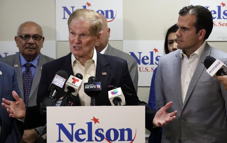 This Oct. 2, 2018 file photo shows U.S. Sen. Bill Nelson, left, speaking to supporters after he was endorsed by Puerto Rico Governor Ricardo Rossello, right, during a news conference in Orlando, Fla. Nelson is facing Florida Gov. Rick Scott. (AP Photo/John Raoux)